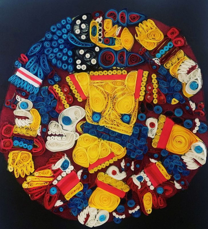 Circular depiction of a naked dismembered Aztec goddess wearing a colorful feather headdress. Decorated with earrings, sandals, bracelets, and a serpent belt.