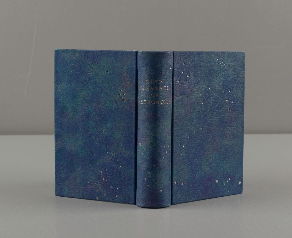 A small, blue, hand-dyed leather bound book with small silver dots in the shape of constellations.