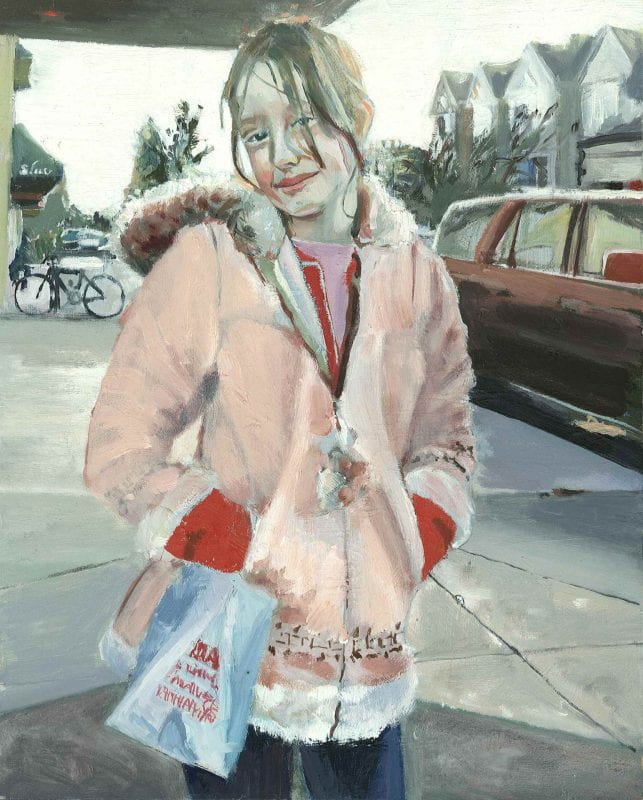 A young girl stands in her faux fur pink coat on a rainy sidewalk, smiling shyly and looking forward.