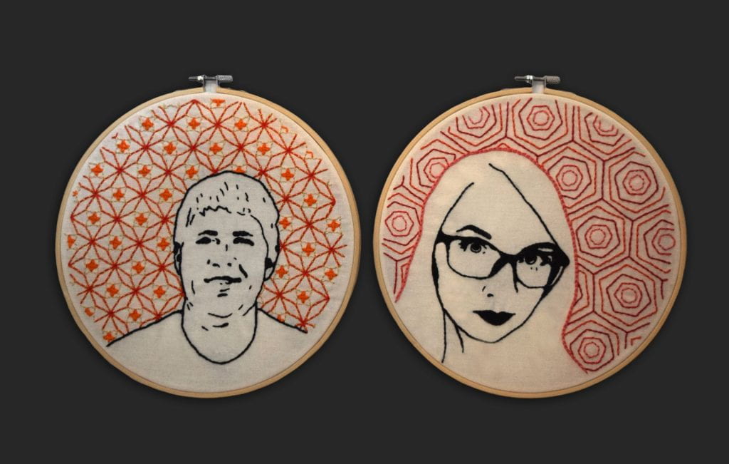 Two round, bamboo embroidery hoops. One with a black line drawing of a young man smiling, the other with a simple line drawing of a young woman. Both with decorative pattern in pink and orange in the background.