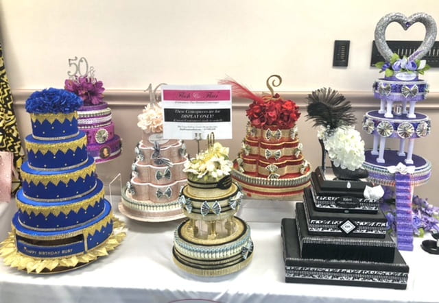 A display of multi-tiered imitation "cakes" in brilliant colors with elaborate decorations.