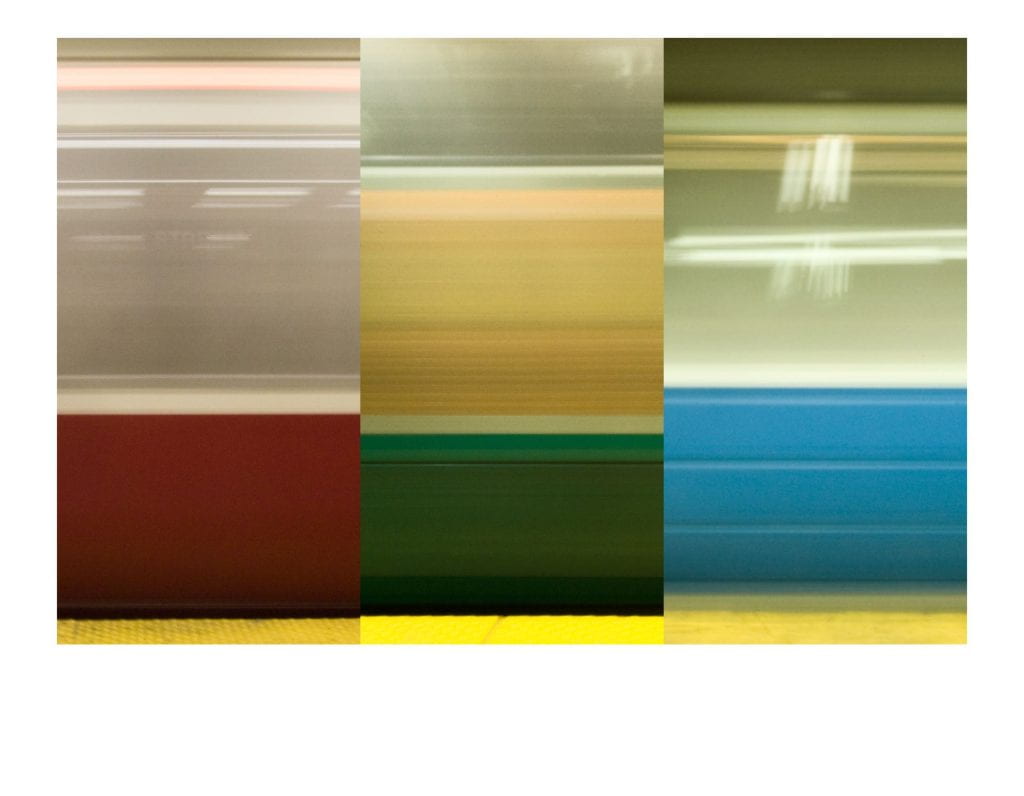 Blurred MBTA subway cars from the red, green, and blue lines.