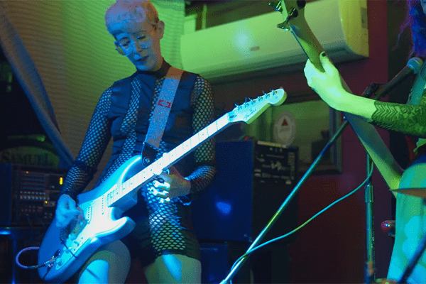 A musician playing an electric guitar on stage.