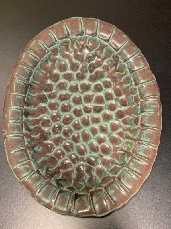 T-1 sculptural clay, in cone 10 glaze (high fired) with blue black glaze (only 1 glaze was used) It broke into the deep textures and pooled, separating the glaze ingredients into two-3 colors- shades of plum & turquoise with some deeper shade of green.