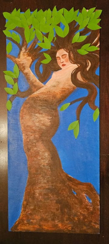 A woman transforming into a tree, eyes closed. From the waist down she has become a brown, twisting trunk; above the waist, her pale skin is being mottled over with bark, her hand stretches out into branches, and leaves spring from her hair and arms.