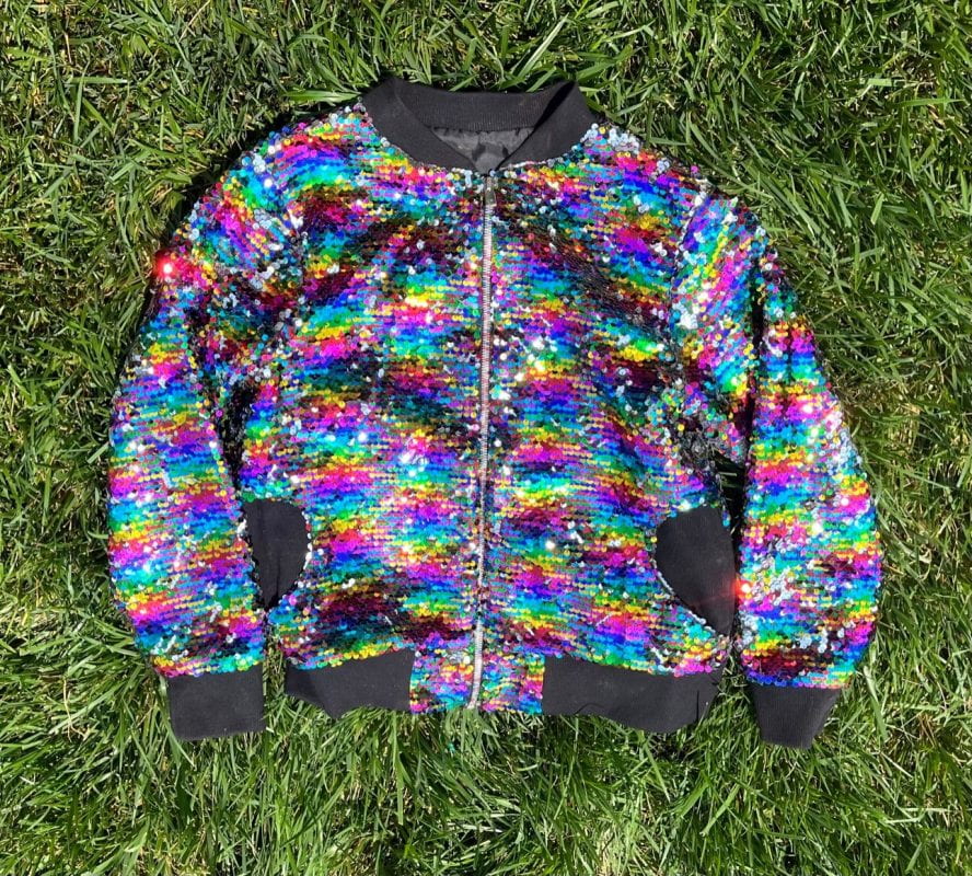 A child's jacket made with bright, rainbow colored sequins.