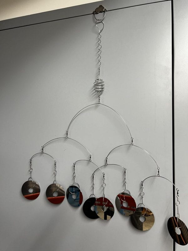A mobile with eight suspended reflective disks.