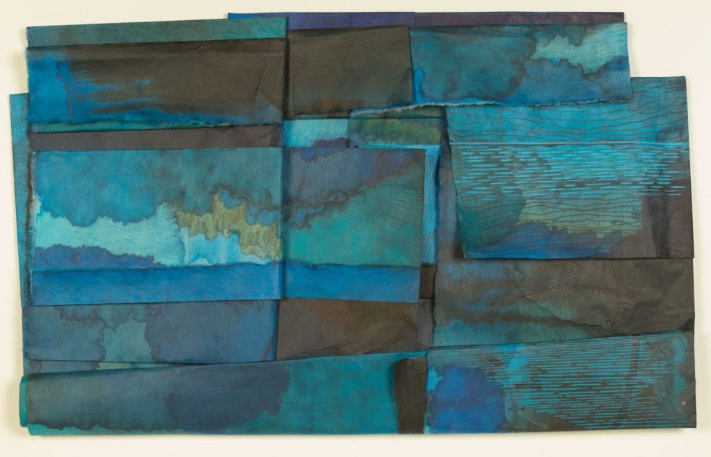 Landscape based image in numerous tones of blue from light to very dark with small amounts of bronze on multiple sheets of folded Japanese paper.