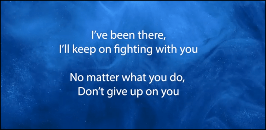 Screenshot of Deannah Blemur's video for Don't Give Up, showing white words against a swirling blue text.