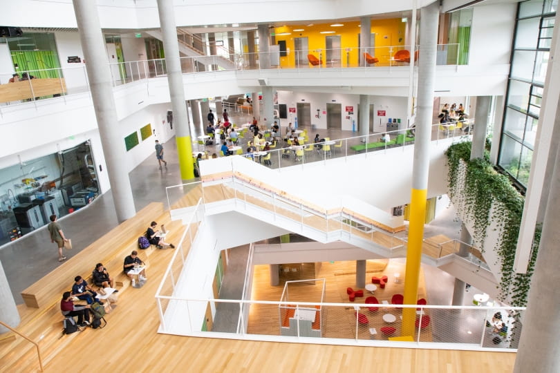 Bird's eye view of the Science and Engineering Complex’s interior showing 3 of the building’s levels and students working in the main atrium.
 

